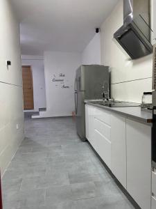 La cuisine est équipée d'un évier et d'un réfrigérateur. dans l'établissement piso acogedor con encanto, à Navas del Rey