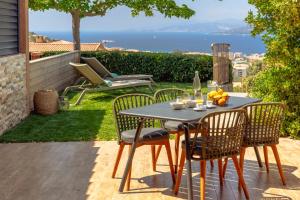 - une table et des chaises sur une terrasse avec vue sur l'océan dans l'établissement Résidence U Frusteru, à Propriano