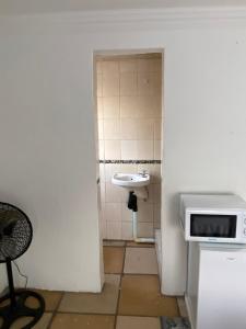 a small bathroom with a sink and a microwave at Soweto Towers Guest Accommodation in Soweto