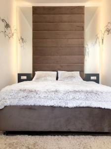 a bedroom with a large bed with a wooden headboard at CarpHouse in Bălţi