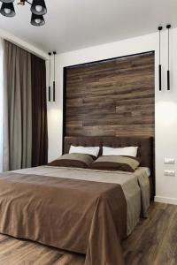 a bedroom with a large bed with a wooden headboard at CarpHouse in Bălţi