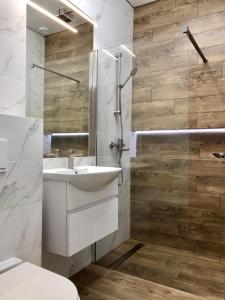 La salle de bains est pourvue d'un lavabo blanc et d'une douche. dans l'établissement CarpHouse, à Bălţi