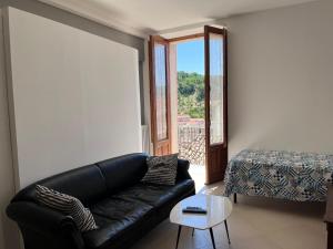 sala de estar con sofá de cuero negro y mesa en Borgo Vivo, en Calitri