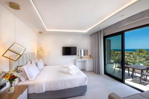 a hotel room with a bed and a balcony at Toska Tower in Chrysi Ammoudia