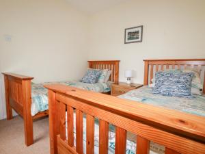 um quarto com 2 camas e um corrimão de madeira em 2 Old Talbot Cottages em Lostwithiel