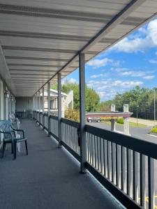 a covered porch with a bench and a road at Gray Wolf Lodge in Manistique
