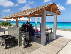 - un groupe de personnes assis sous un pavillon sur la plage dans l'établissement Delfins Beach Resort, à Kralendijk
