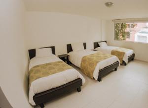 a bedroom with two beds and a window at Hotel Parque Reservado in Pasto