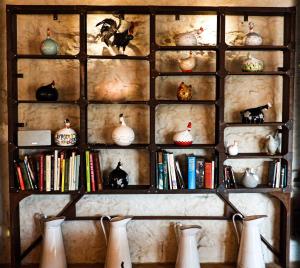 a book shelf filled with books and vases at La ferme du Comte in Durbuy