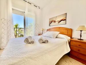 1 dormitorio con 1 cama con toallas en Apartamento Playa Calahonda El Farillo con terraza, en Calahonda