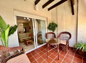 una sala de estar con una mesa y sillas en un porche en Apartamento Playa Calahonda El Farillo con terraza, en Calahonda