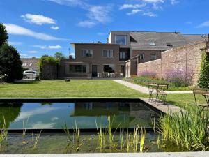 ein Haus mit einem Teich davor in der Unterkunft Tuss in Kortrijk