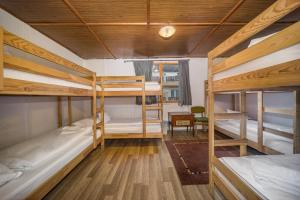 シルヴァーシュヴァーラドにあるLipicai Ifjúsági Szállóの二段ベッド3台、テーブルが備わるドミトリールームです。
