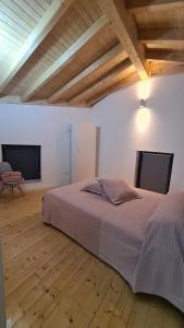 a bedroom with a bed and two flat screens at O Cantinho da Penetra AL in Santar