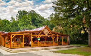 einen Holzpavillon mit Blumen in einem Park in der Unterkunft Lipicai Ifjúsági Szálló in Szilvásvárad