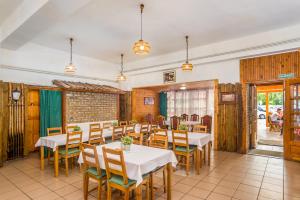 a restaurant with tables and chairs in a room at Lipicai Ifjúsági Szálló in Szilvásvárad