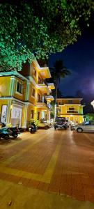 a building with cars parked in a parking lot at night at Casa de Laura in Calangute