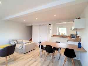 a kitchen and living room with a table and chairs at petite maison proche centre ville in Bréhal