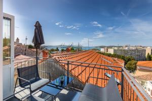 un balcon avec un toit orange et un parasol dans l'établissement Pula Bay View apartment, à Pula