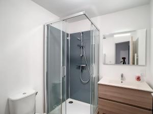a bathroom with a shower and a toilet and a sink at petite maison proche centre ville in Bréhal +24 photos