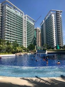 um grupo de pessoas numa piscina com edifícios em Azure Urban Resort Residences 2-BR Balcony Amenity View by Casa Rafael em Manila