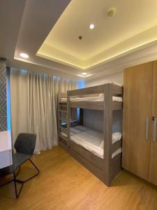um quarto com 2 beliches e uma secretária em Azure Urban Resort Residences 2-BR Balcony Amenity View by Casa Rafael em Manila