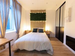 a bedroom with a large white bed with a window at Le Cinq : Appartement Chic&Cosy, jardin privatif in Vesoul