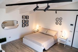 Habitación blanca con cama y espejo en Blanco - MAGNIFICENT B&B Altamura, en Altamura