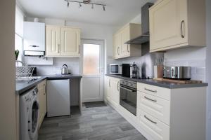 a white kitchen with white cabinets and appliances at Ludlow Drive 3 bed Contractor family Town house in melton Mowbray in Melton Mowbray