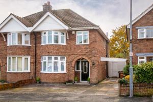 a red brick house with a white garage at Ludlow Drive 3 bed Contractor family Town house in melton Mowbray in Melton Mowbray
