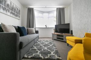 uma sala de estar com um sofá e uma televisão em Ludlow Drive 3 bed Contractor family Town house in melton Mowbray em Melton Mowbray