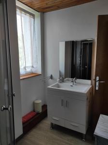 a bathroom with a sink and a mirror and a window at La Cabanette in Saint-Agrève