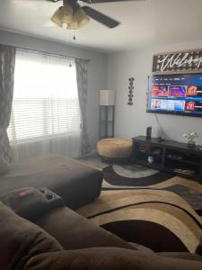 a living room with a couch and a flat screen tv at Comfy 3 Bed 2 Bath EZ Access To Santa's Wonderland in College Station