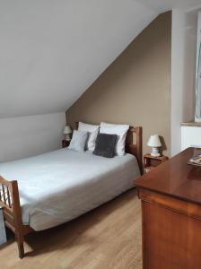 a bedroom with a bed and a wooden desk at La Cabanette in Saint-Agrève