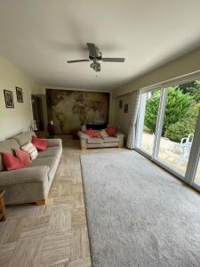 sala de estar con sofá y ventilador de techo en Kerprimel, en Saint-Thois