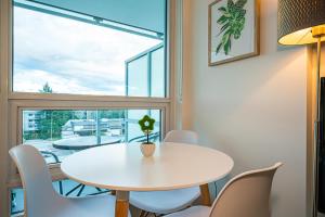 einen weißen Tisch und Stühle in einem Zimmer mit Fenster in der Unterkunft Charming Oasis Close to Airport & Downtown Views in Richmond