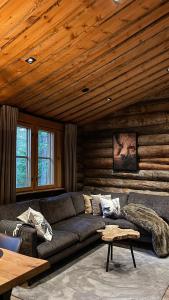 a living room with a couch and a wooden ceiling at Cottis - Kultakettu in Levi