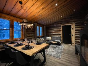 a dining room with a table in a log house at Cottis - Kultakettu in Levi