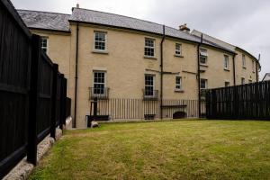 uma casa grande com uma cerca em frente em Escape Ordinary at Devenish Manor em Enniskillen