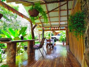 a patio with a table and chairs on a wooden floor at Onca Tours & Treehouses in Rio Celeste