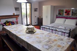 een slaapkamer met 2 bedden en een tafel met een theepot erop bij La Collina del Melograno in Sinalunga