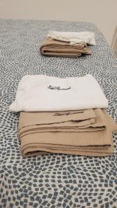 a pile of towels sitting on a bed at B&B Lido Apartament 10B in Civitanova Marche