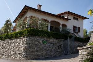 een huis achter een stenen muur met een hek bij La Collina del Melograno in Sinalunga