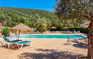 - une piscine avec des chaises longues et des parasols dans l'établissement Cozy Home In Estepa With Kitchen, à Estepa