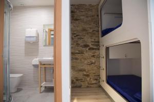uma casa de banho com um quarto com uma televisão na parede em Hostel Cross em Lugo
