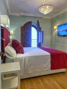 Schlafzimmer mit einem Bett und einem Kronleuchter in der Unterkunft SUITES SAN ESTEBAN 16 Principe in Sevilla
