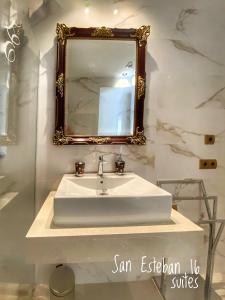 ein Badezimmer mit einem weißen Waschbecken und einem Spiegel in der Unterkunft SUITES SAN ESTEBAN 16 Principe in Sevilla