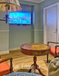 ein Wohnzimmer mit einem Couchtisch und einem TV in der Unterkunft SUITES SAN ESTEBAN 16 Principe in Sevilla