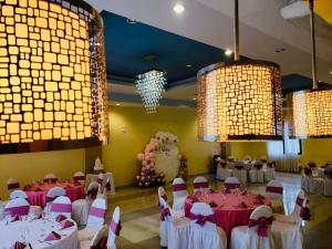 un salón de banquetes con mesas, sillas y lámparas de araña en HOTEL PRIMAVERA BOUTIQUE, en San Pedro Sula