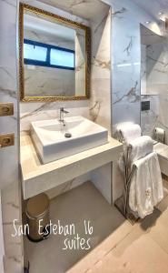 ein Badezimmer mit einem weißen Waschbecken und einem Spiegel in der Unterkunft SUITES SAN ESTEBAN 16 Principe in Sevilla